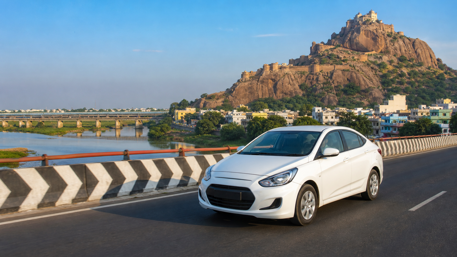 White taxi on a Trichy road with Rockfort scenery in the background